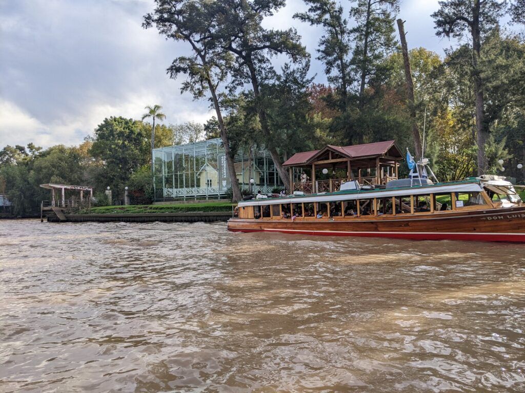 A scenic boat ride on the Tigre river with lush greenery and colonial-style buildings