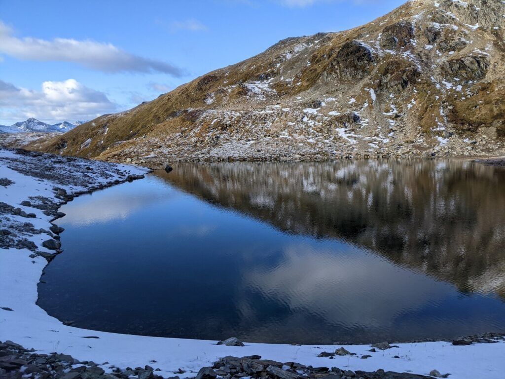 A picturesque turquoise lake surrounded by rugged snow-capped mountains