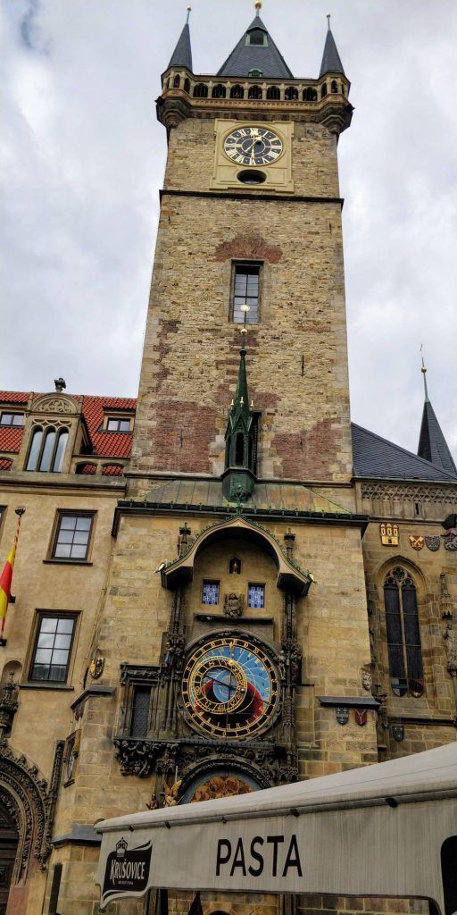 An intricate astronomical clock with multiple dials displays modern-style time and the current moon phase.