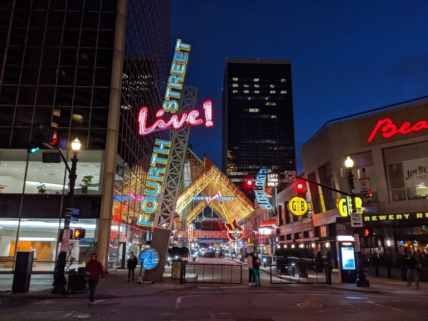 A nighttime view of downtown Louisville, Kentucky, featuring illuminated city buildings creating a vibrant urban landscape.